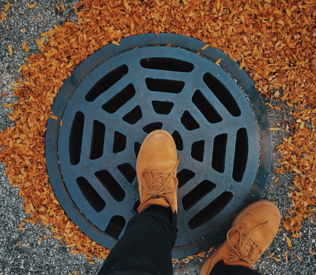 Stepping onto a manhole cover/drain.