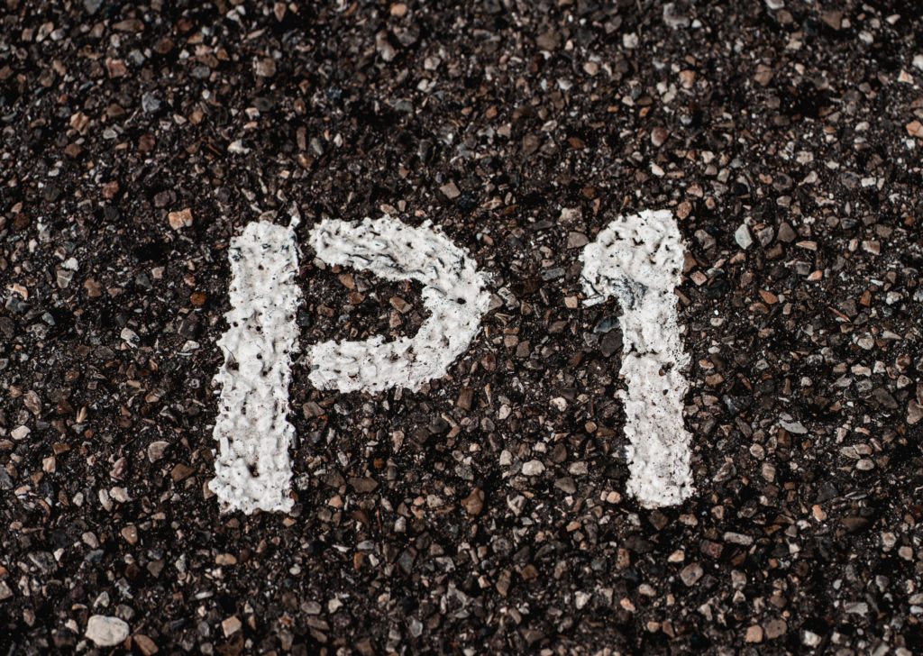 Letter 'P' and number '1' spray painted on tarmac