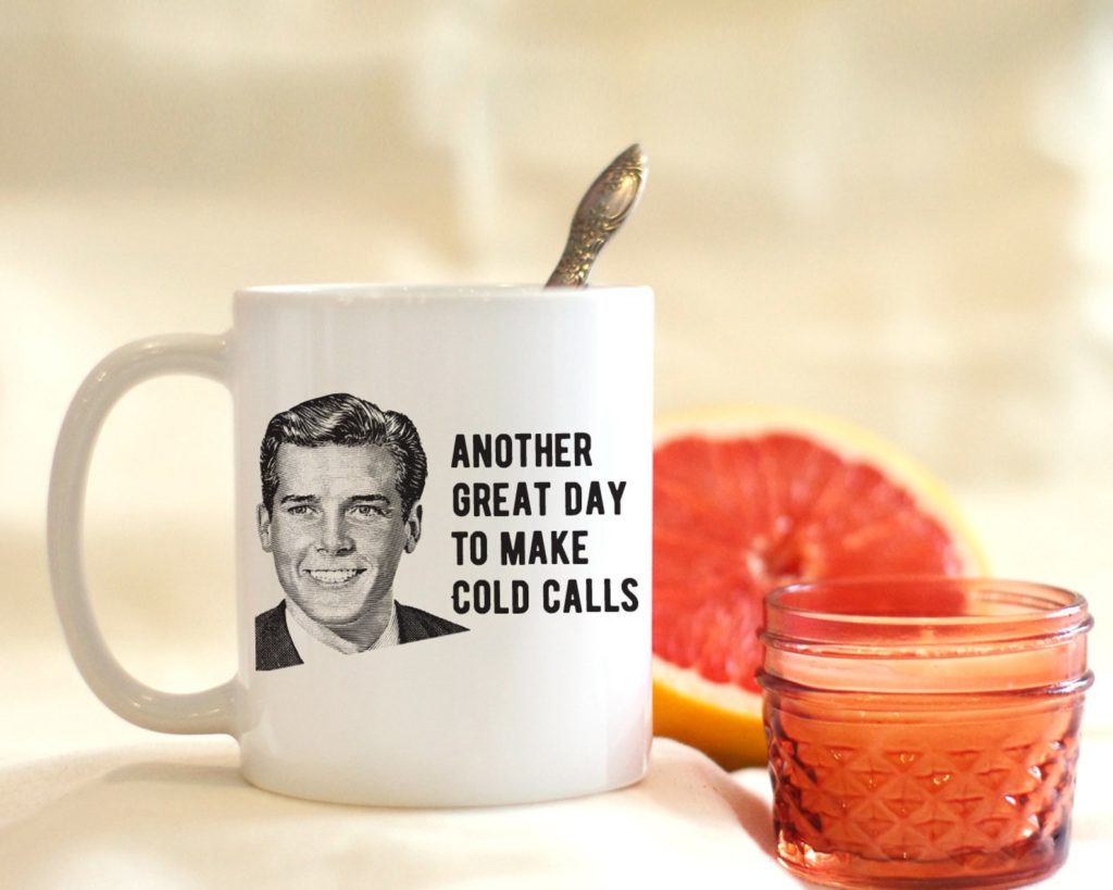 A coffee mug with the inscription, "Another Great Day to Make Cold Calls"