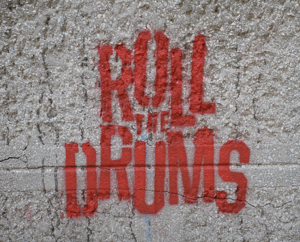 Wall painted with the phrase, "Roll the Drums."