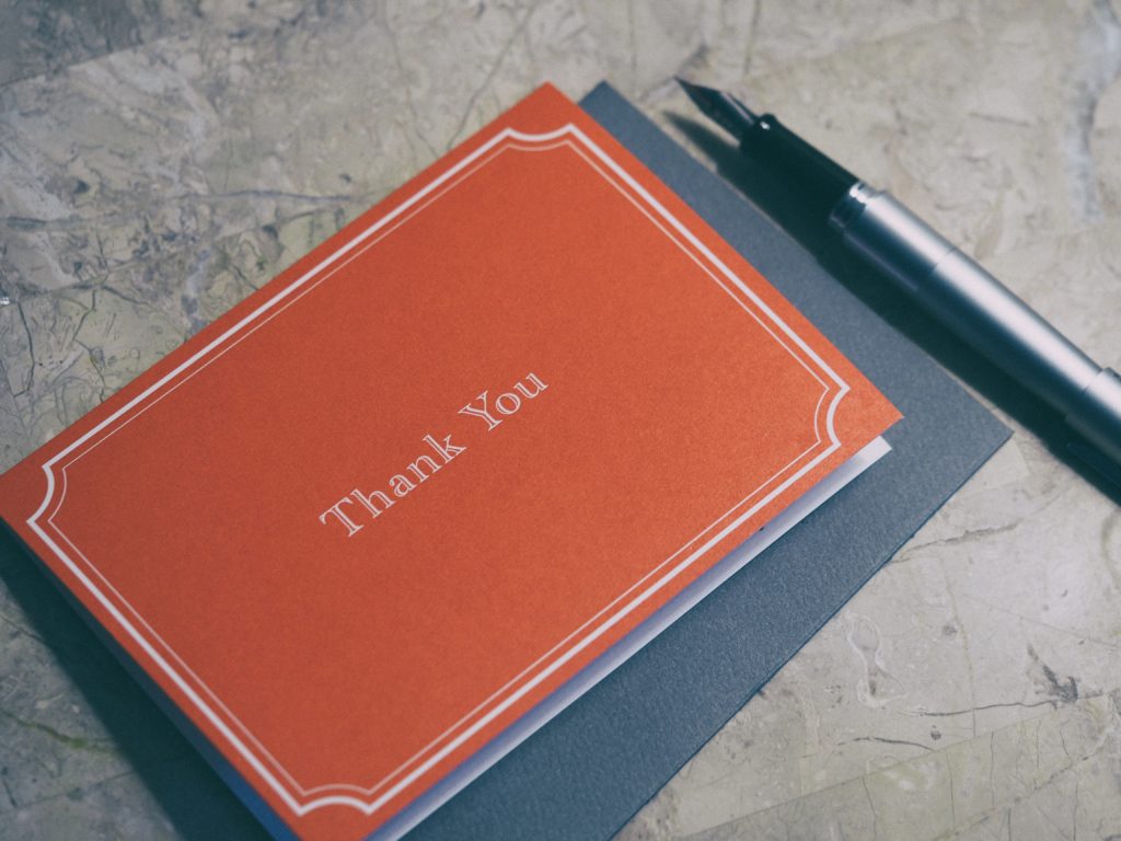 Thank You card and ink pen laying on a table