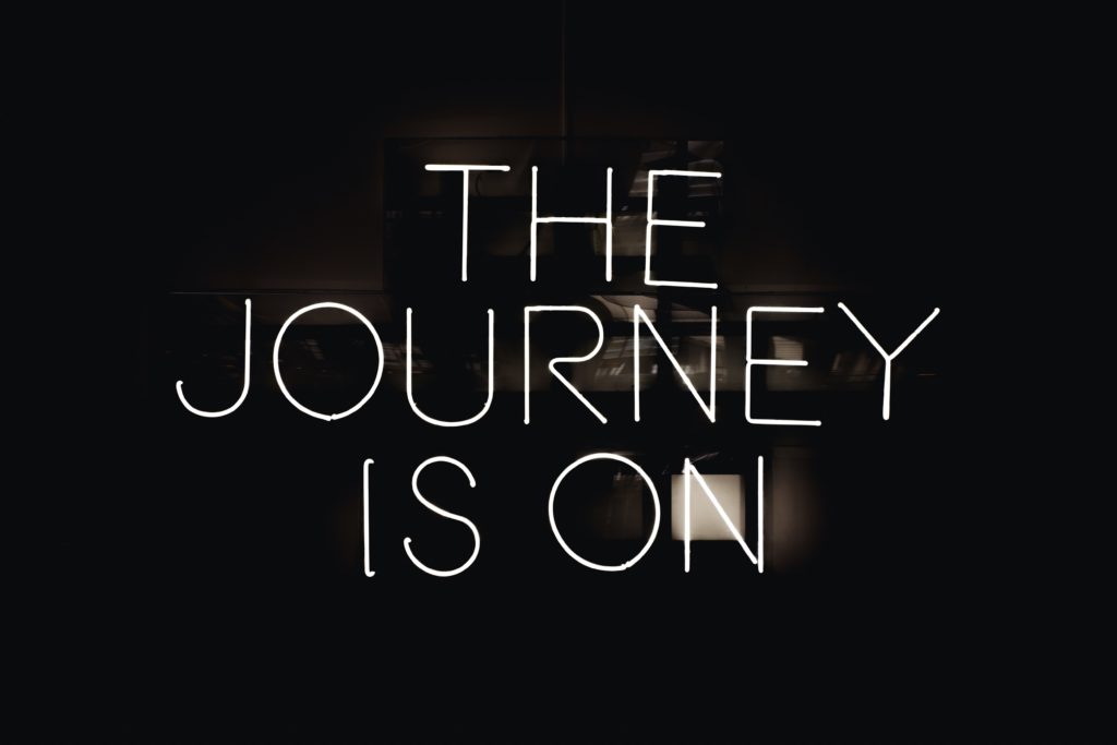 Neon sign depicting, "The Journey is On."