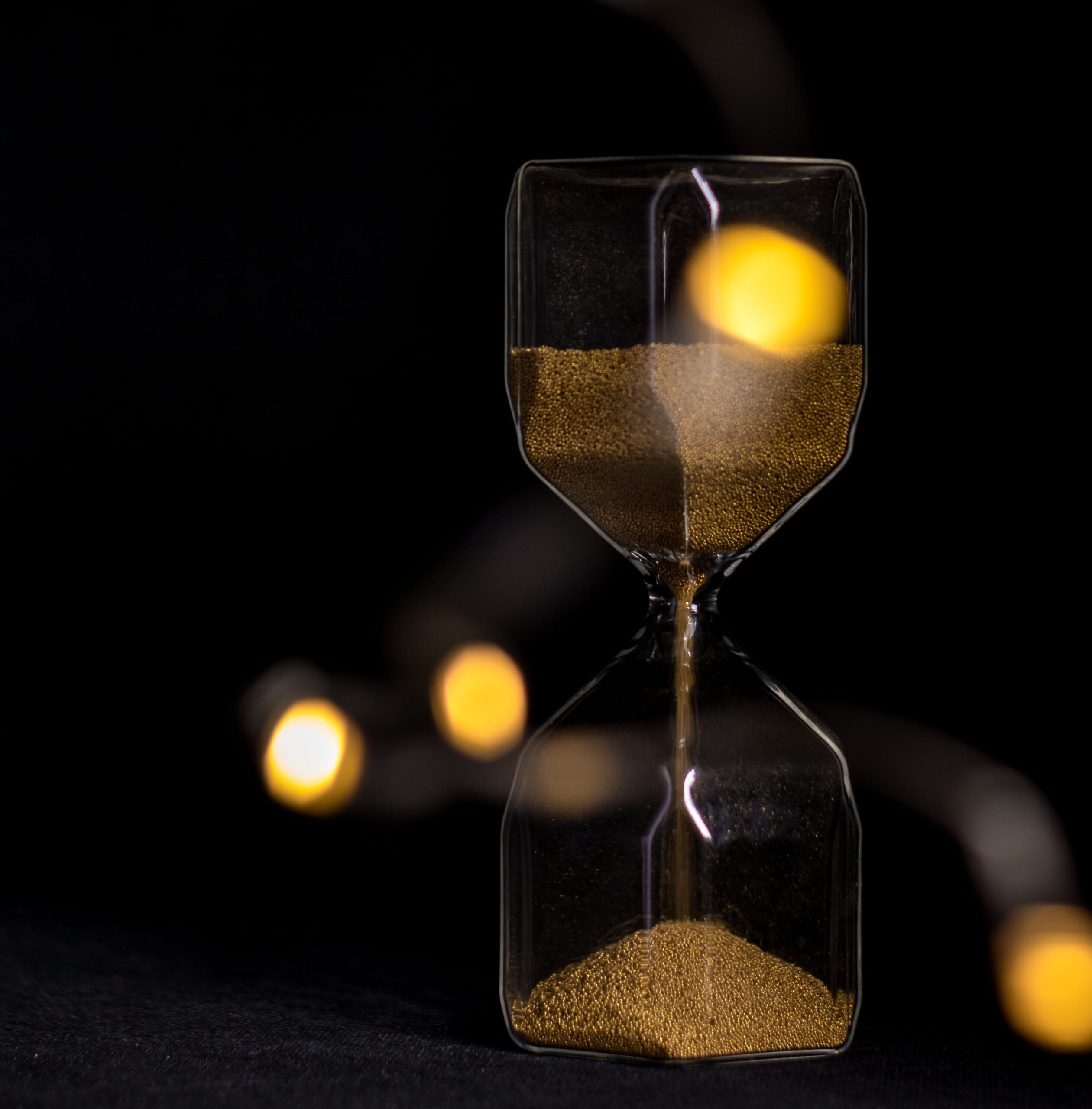 Hour glass with sand dropping from the top to the bottom.