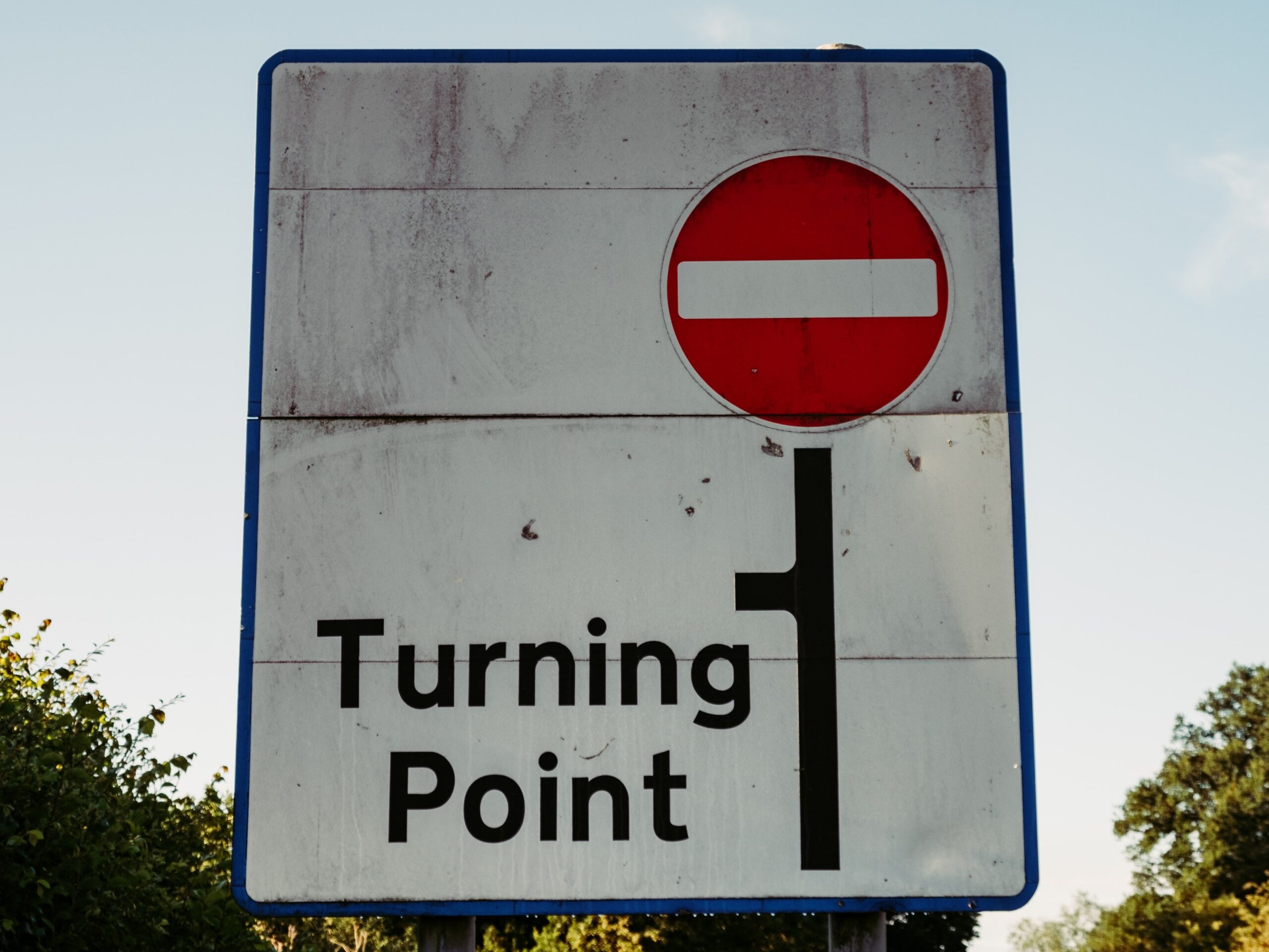 Road sign warning of a turning point before a Do Not Enter sign.