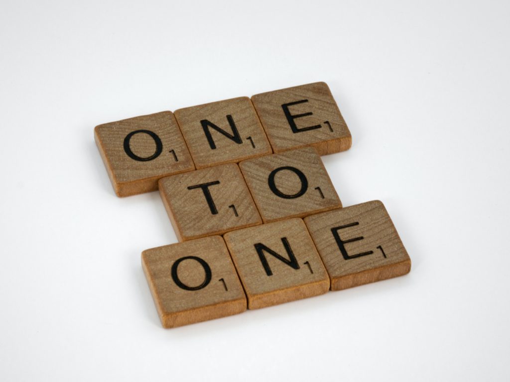 Pieces of the board game Scrabble, spelling out "one to one."