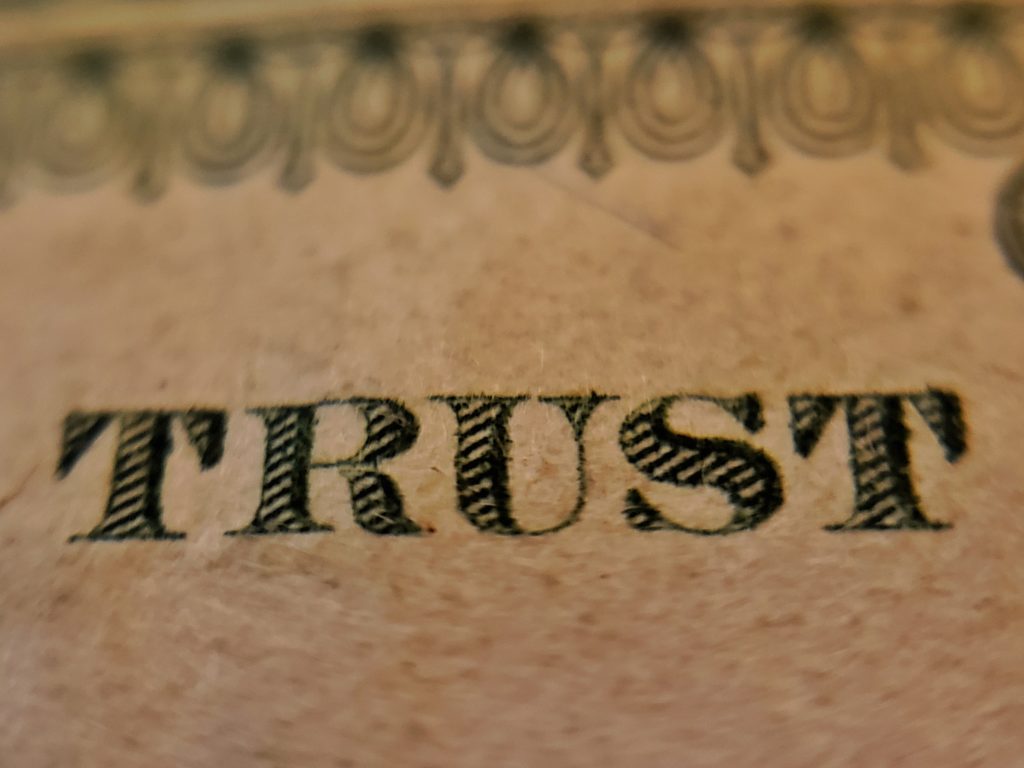 Close up on the word "Trust" on a bill of U.S. currency.