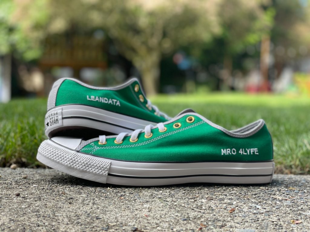 Close up photo of a pair of green shoes with LeanData sewed on the side of one, "MRO 4LYFE" sewed on the other.