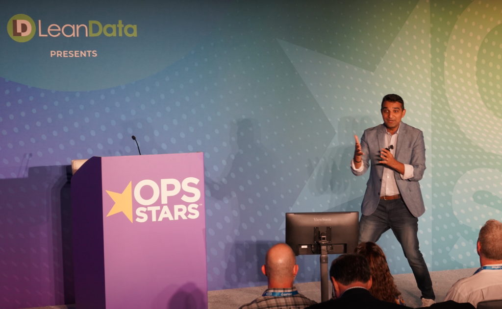 Sangram Varje onstage delivering a presentation at OpsStars 2022.