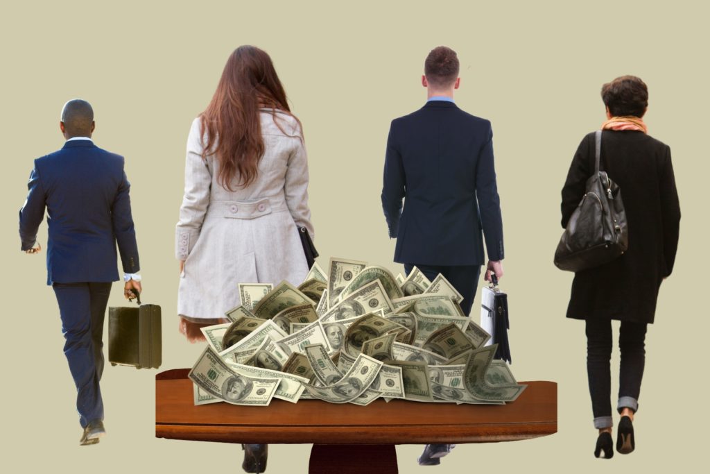 Image of four business professional walking away from a table stack high with currency. 