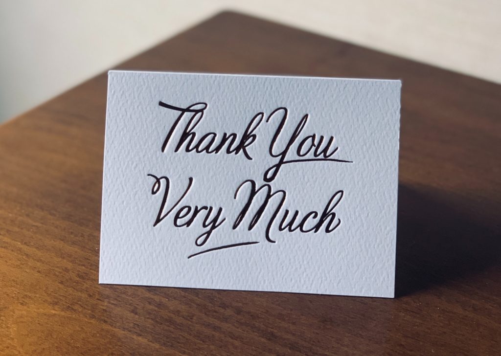 Image of a Thank You card standing on a desk.