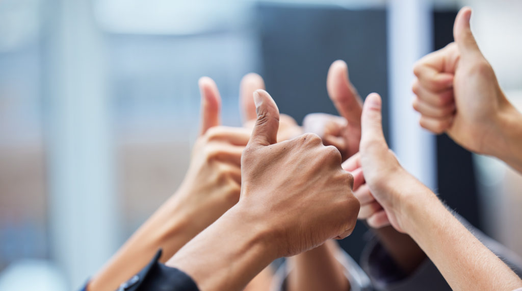 Close up of a group of hands all giving a 