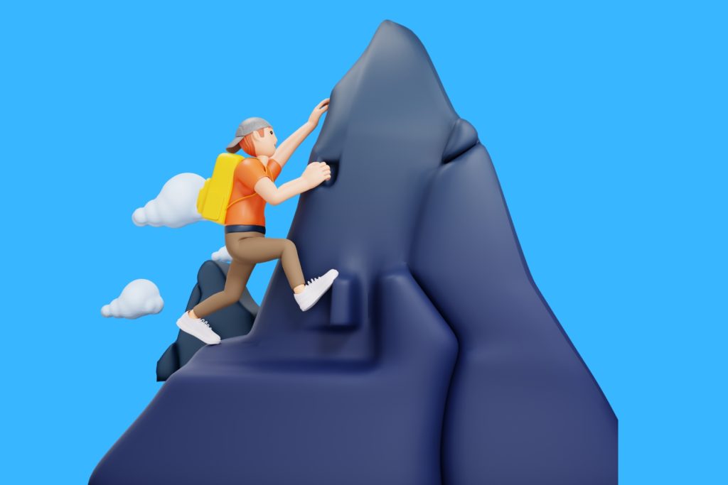 Image of a man summiting a steep peak.