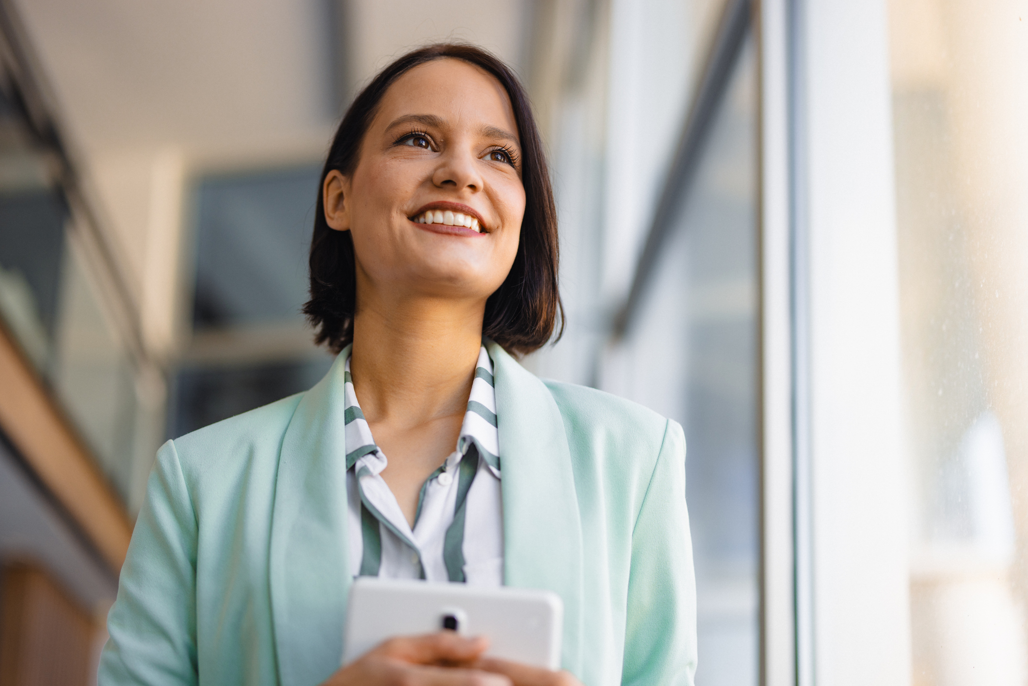 Portrait of modern young businesswoman with digital tablet in office