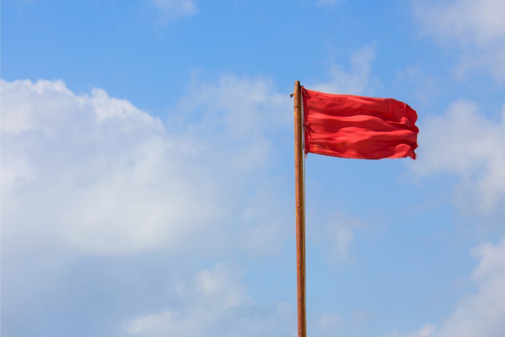 Image of a red flag against a blue sky background.
