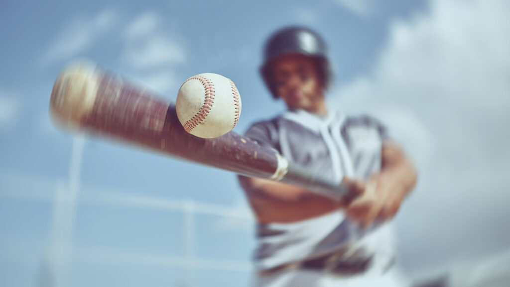 A baseball batter takes a swing at a pitched ball.