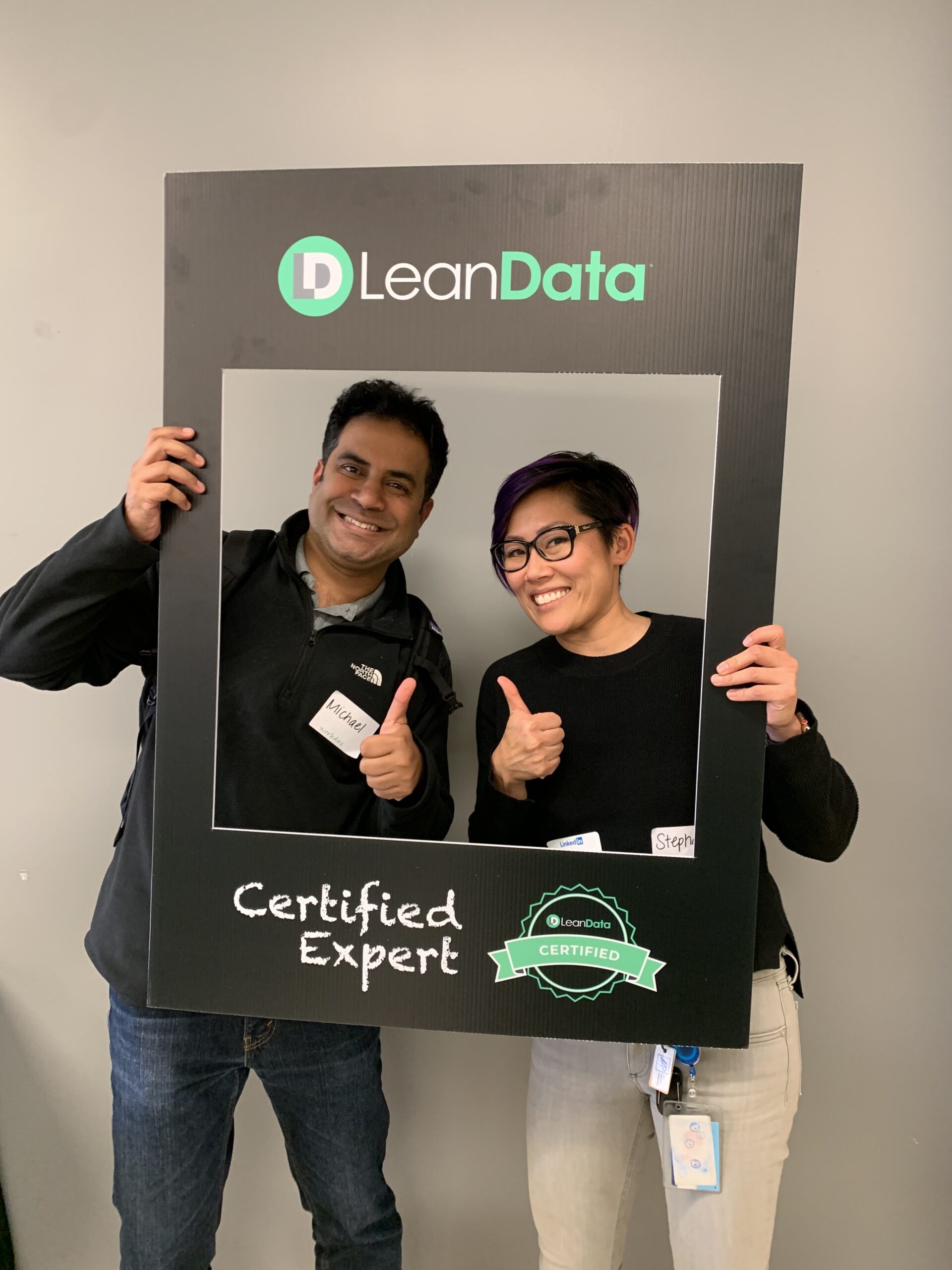 two professional workers getting their picture taken at a LeanData certification event