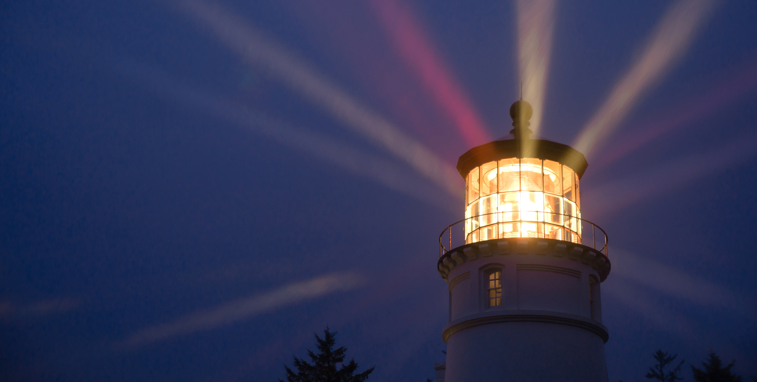 Lighthouse beams at night.