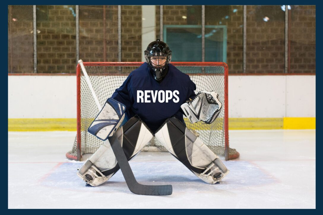 hockey player in the goal box wearing a RevOps jersey