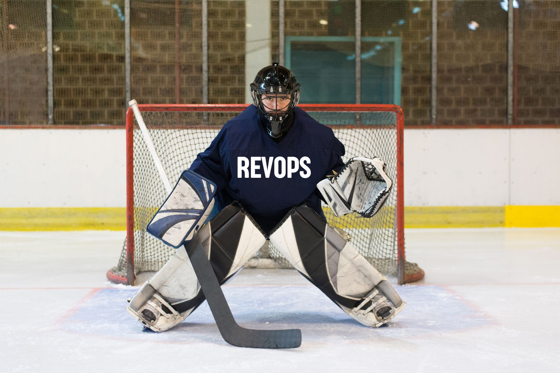 hockey goalie in the goal wearing a RevOps jersey