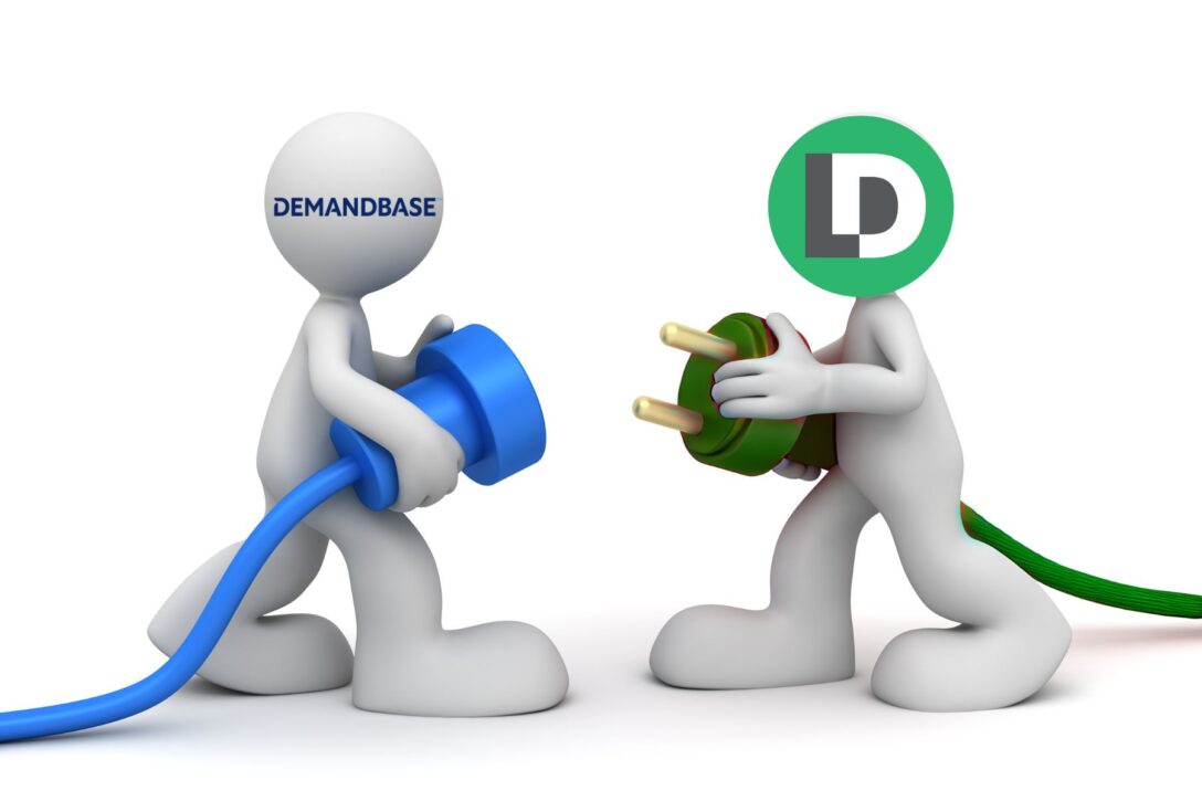 white 3D figures holding a blue plug and a green plug representing LeanData and Demandbase