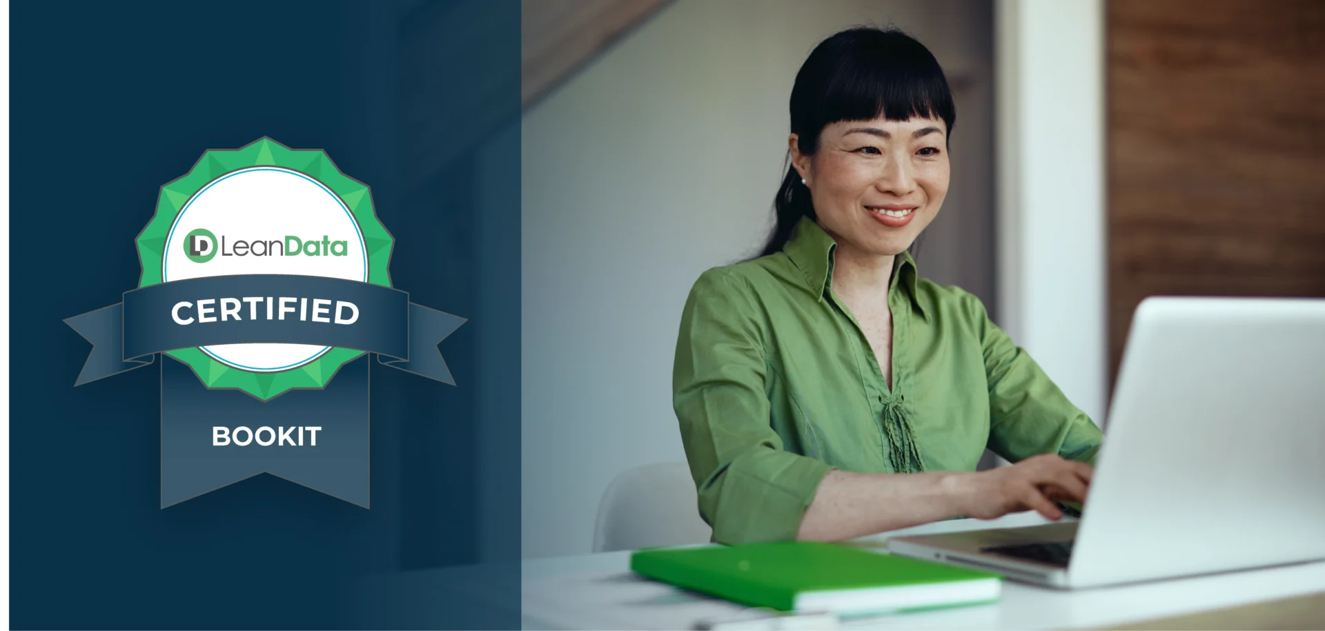 professional woman smiling while using a laptop at a desk